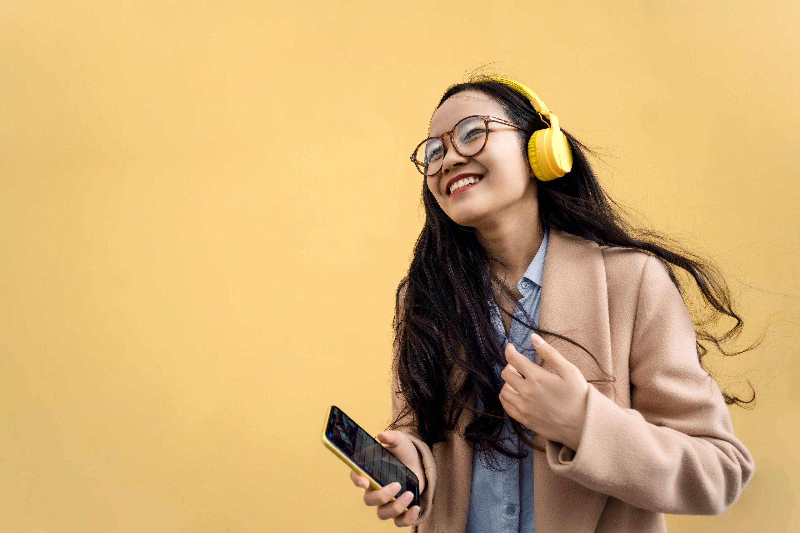 woman with headphones streaming music form her phone